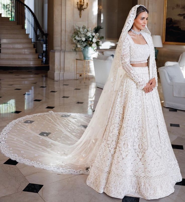 a woman in a white wedding dress standing on the floor