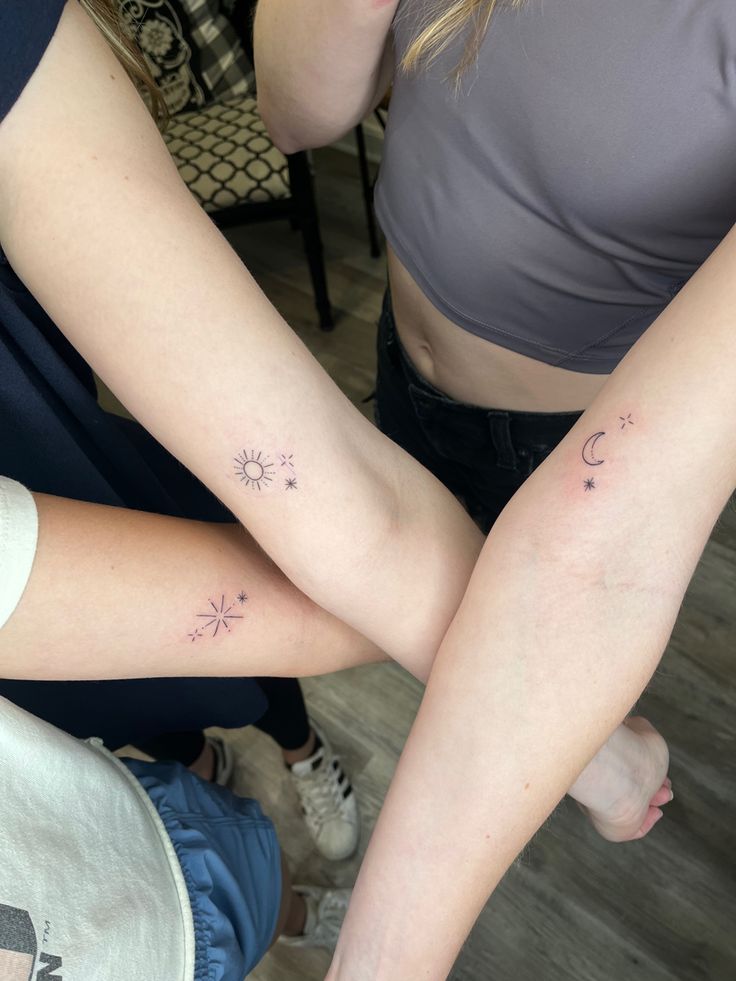 two people with tattoos on their arms and legs, one is holding the other's arm