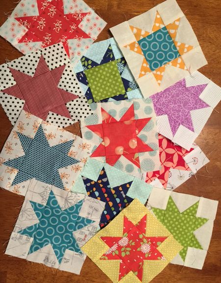 many different types of quilts are laid out on the table top, including one star