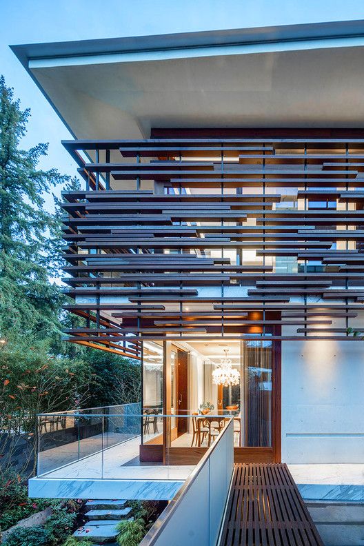 a modern house with wooden slats on the roof and stairs leading up to it