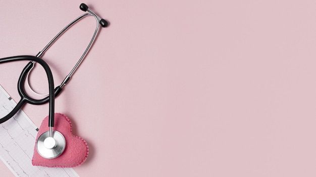 a stethoscope laying on top of a piece of paper next to a pink heart