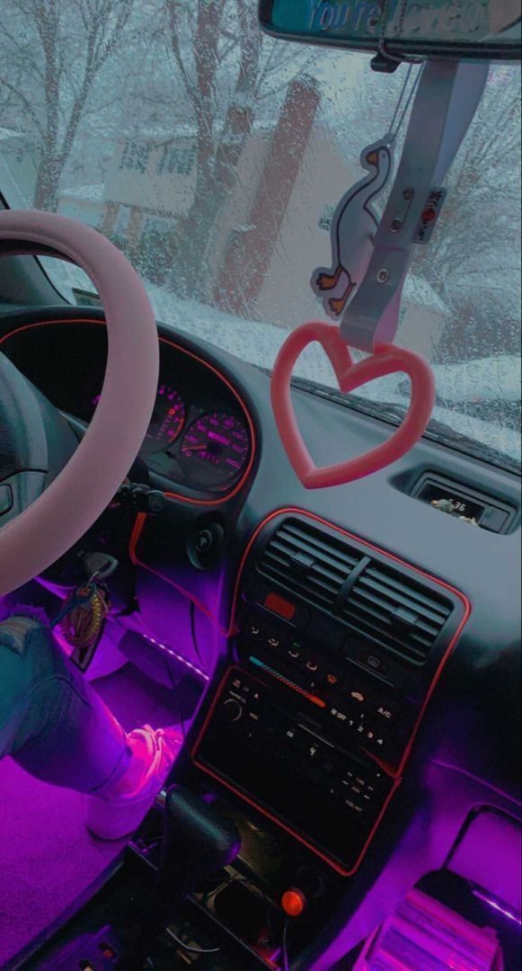 the interior of a car is lit up with purple lights and heart - shaped decorations