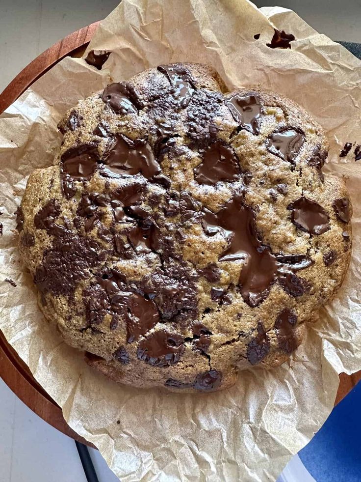 a chocolate chip cookie sitting on top of a piece of wax paper