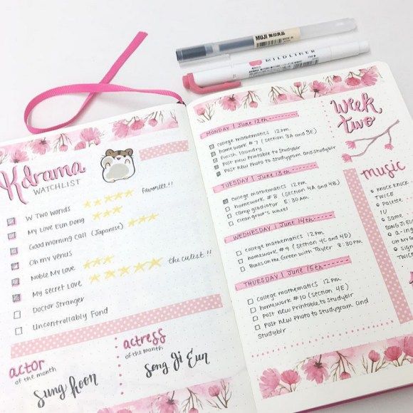 an open planner with pink flowers and writing on it