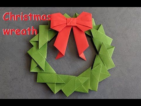 an origami wreath with a red bow on it and the words christmas wreath