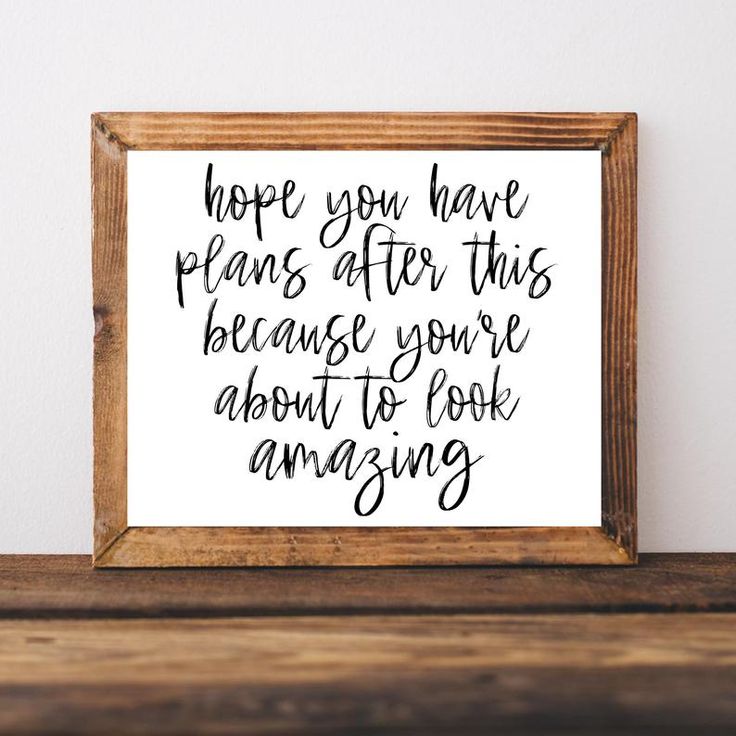 a wooden frame with a handwritten quote on it sitting on a shelf next to a wall