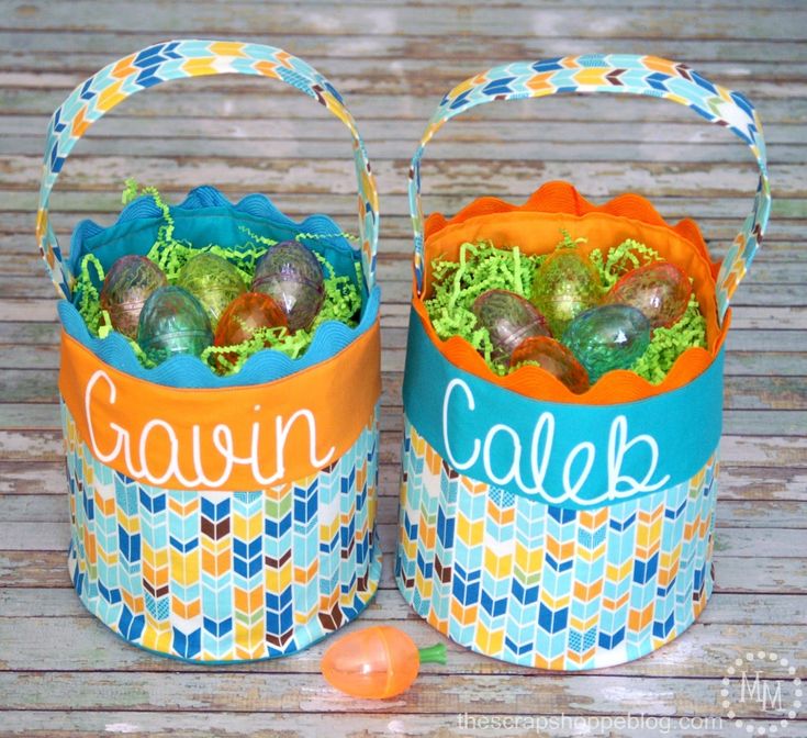 two baskets filled with easter eggs sitting on top of a wooden table