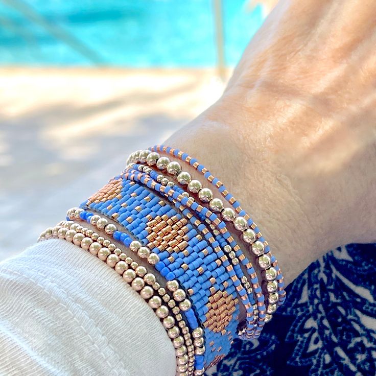 Pretty in Periwinkle Beaded Bracelets Band: Flat woven; 1/2"w; 14K yellow/rose gold-filled or sterling silver clasp & 1" extender chain; glass seed beads. Strands: Stretch style; 14K yellow/rose gold-filled or sterling silver round 2mm, 3mm & 4mm beads; glass seed beads. Wrap: Stretch style that will wrap around the wrist 3 times (can also be worn as a necklace); glass seed beads. (When adding to cart, select your single bracelet size, and it will be multiplied in length by three when made). Sho Dainty Blue Bracelets With Tiny Beads, Rose Gold Bracelets With Colorful Round Beads, Rose Gold Bracelet With Colorful Round Beads, Blue Bracelets With Tiny Beads For Friendship, Blue Friendship Bracelets With Gold Beads As Gift, Blue Friendship Bracelets With Gold Beads, Dainty Blue Round Bead Bracelets, Adjustable Blue Friendship Bracelets With Gold Beads, Blue Tiny Beads Stretch Bracelet For Friendship