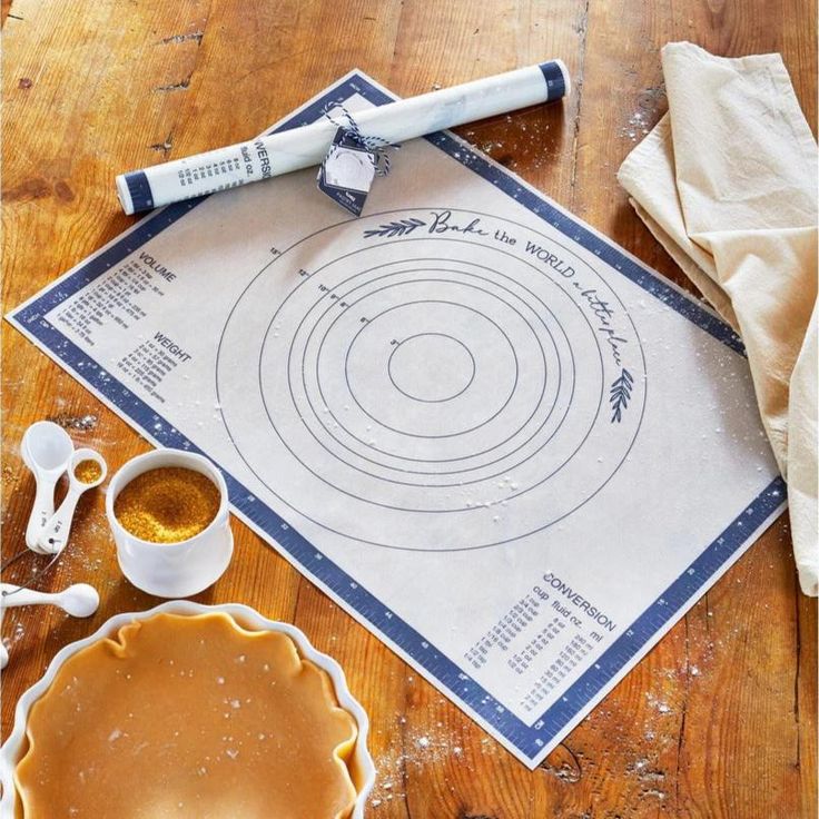 a table with pie crusts and baking utensils on it, including a rolling pin