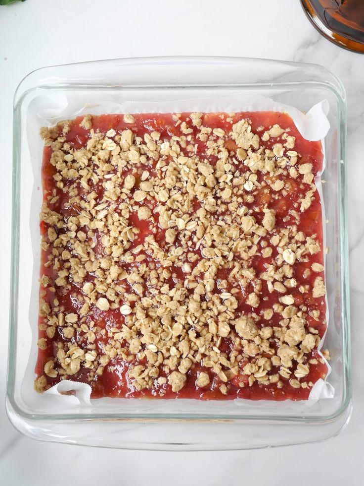 a square glass dish filled with crumbled toppings