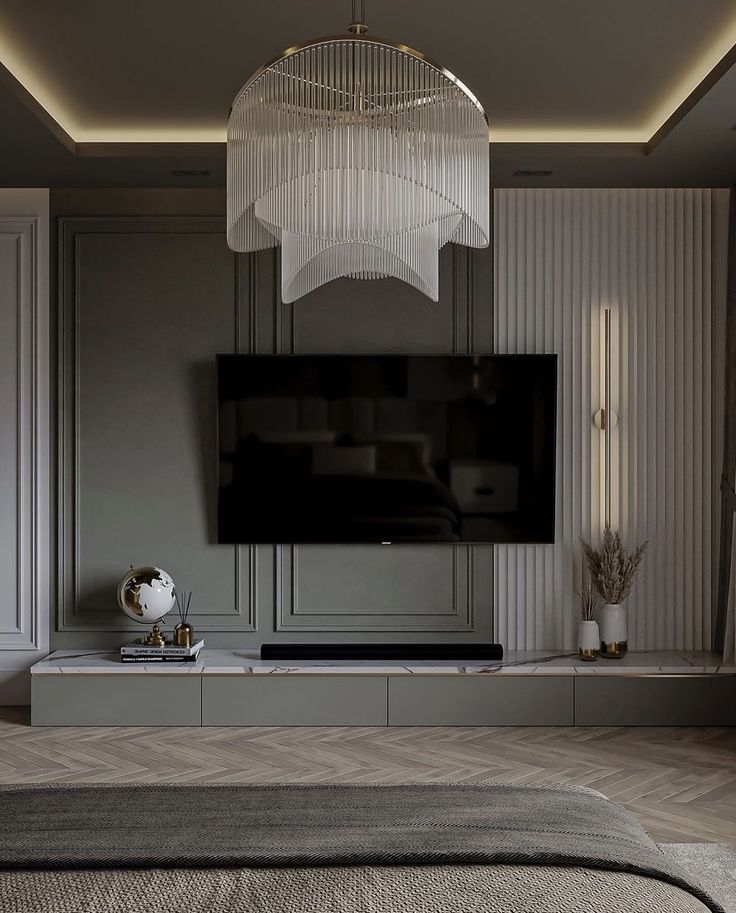 a modern living room with a large flat screen tv and chandelier hanging from the ceiling