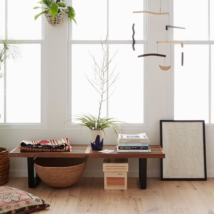 a living room filled with furniture and potted plants on top of windowsills