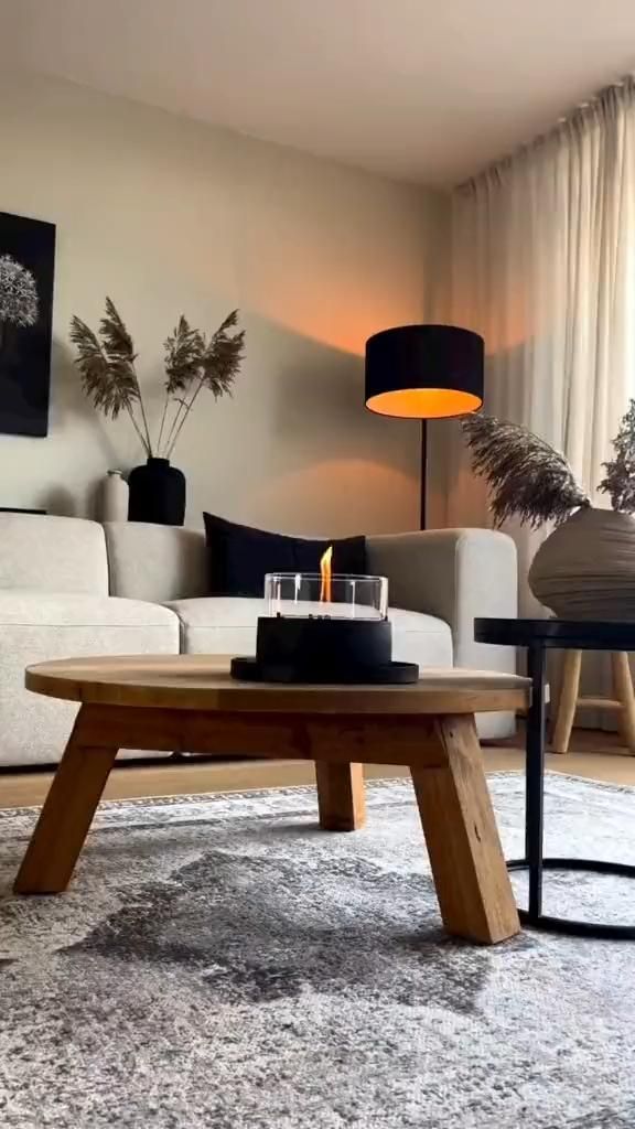 a living room filled with furniture and a fire place on top of a coffee table