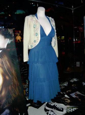 a dress and shoes are on display in a room with posters, pictures, and other items