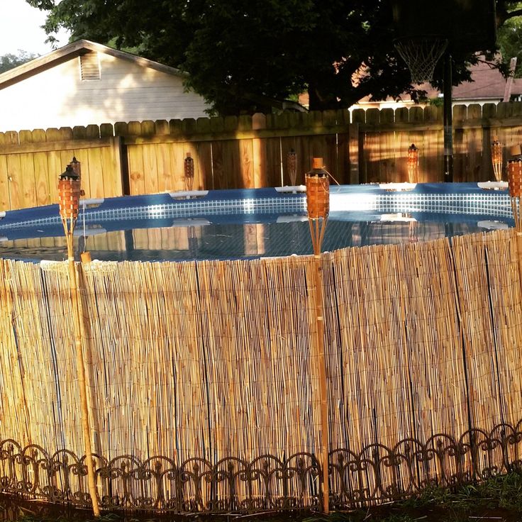 a bamboo fence surrounding an above ground pool