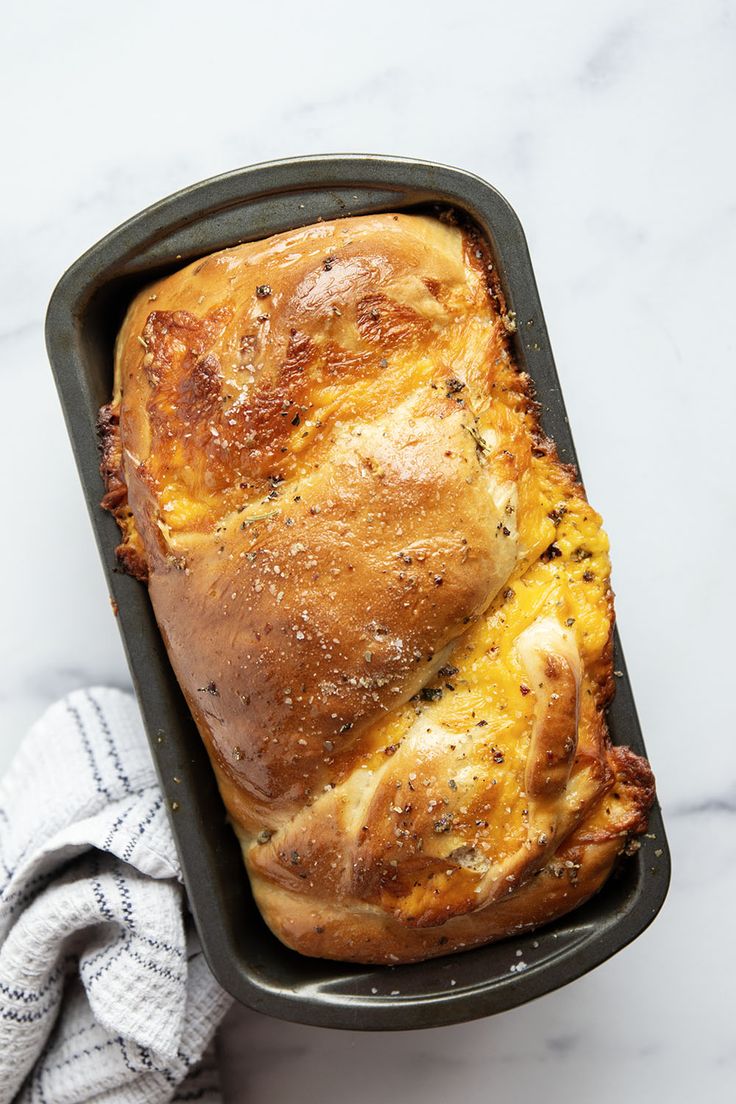 a loaf of bread sitting in a pan on top of a white marble countertop