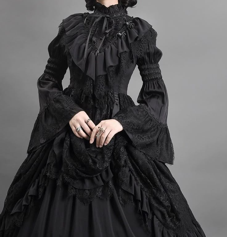 Step into a world of gothic elegance with our Black Gothic Lolita Ball Gown. This Victorian-inspired dress, adorned with layered tulle ruffles, is perfect for those seeking a dramatic and sophisticated look. Luxurious Black Fabric: Made from rich black fabric with intricate lace detailing, this gown exudes timeless gothic charm, ideal for formal events and themed occasions. Victorian-Inspired Design: The fitted bodice features exquisite lace patterns and a high collar, enhancing your silhouette Gothic Vampire Dress Victorian, 18th Century Gothic Fashion, Victorian Gothic Gown, Diy Victorian Dress, Victorian Goth Clothes, Victorian Dress Design, Dark Victorian Dress, Black Ruffle Dress Outfit, Victorian Gothic Outfit