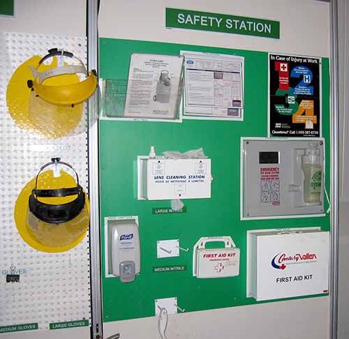 a green and white wall mounted to the side of a building with safety signs on it