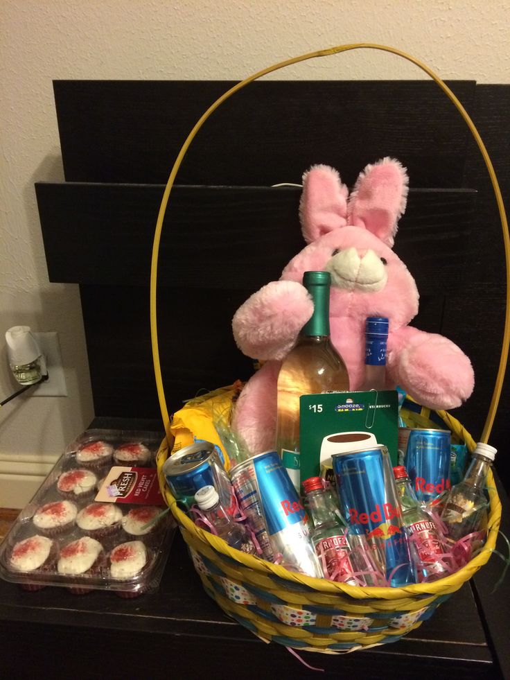 a basket filled with cupcakes, drinks and a stuffed bunny