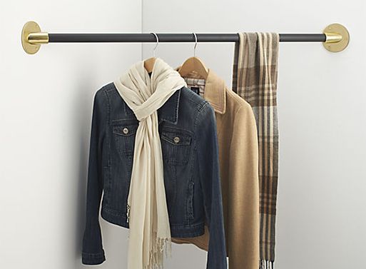 two coats hanging on a coat rack with scarfs