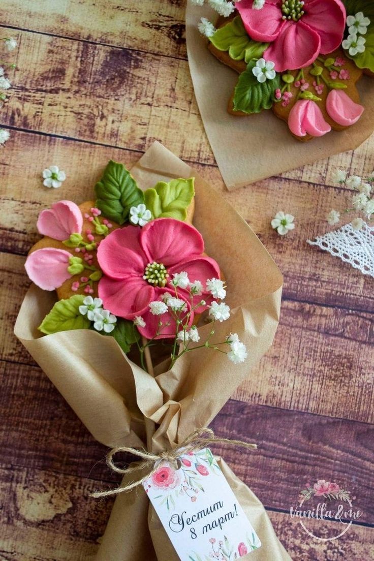 some flowers are wrapped in brown paper on a wooden table with a tag attached to it