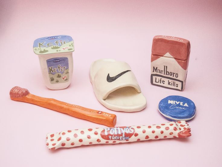 some toys are laying out on a pink surface with one toy toothbrush and the other is an ice cream