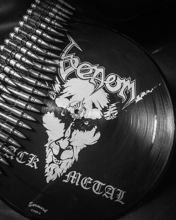 a black and white photo of a metal comb with an image of a demon on it