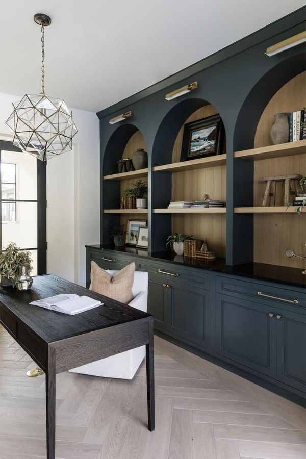 a living room filled with lots of furniture next to a wall mounted bookshelf