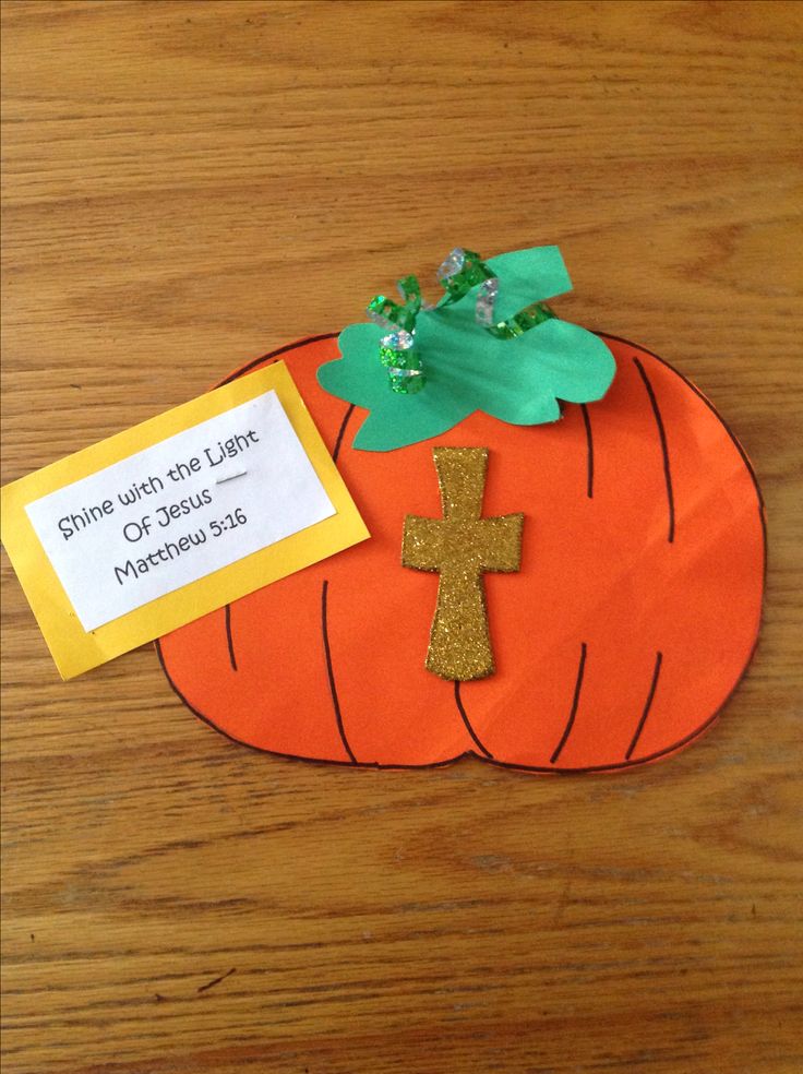 an orange paper pumpkin with a cross on it and a note attached to the front