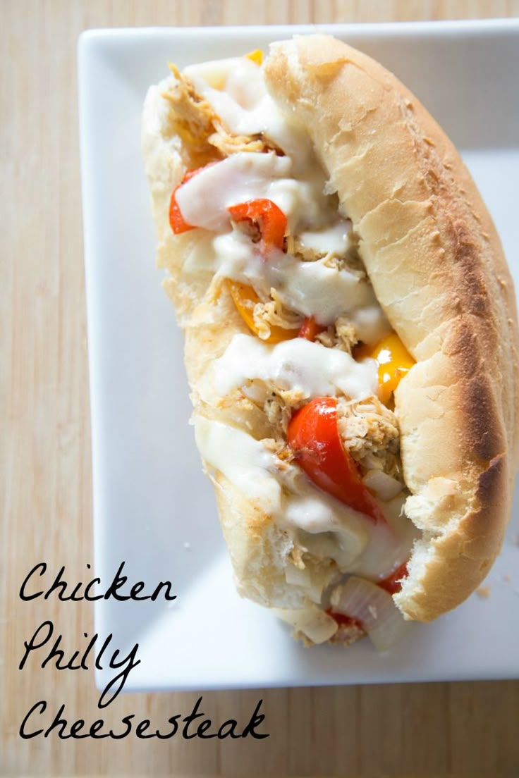 a chicken phily cheesesteak sandwich on a white plate with the words chicken phily cheesesteak