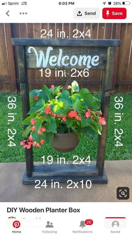 a welcome sign with potted plants in it