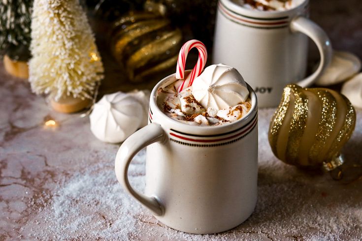 two mugs filled with hot chocolate and candy canes