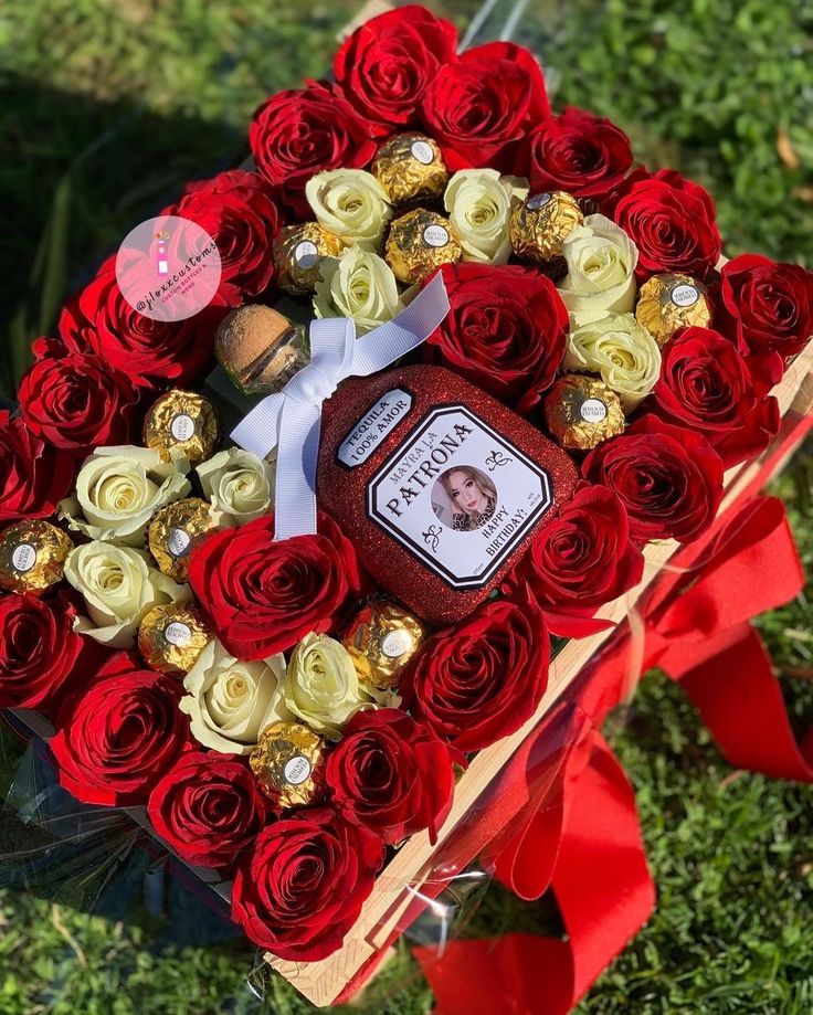 a heart shaped box filled with roses and chocolates