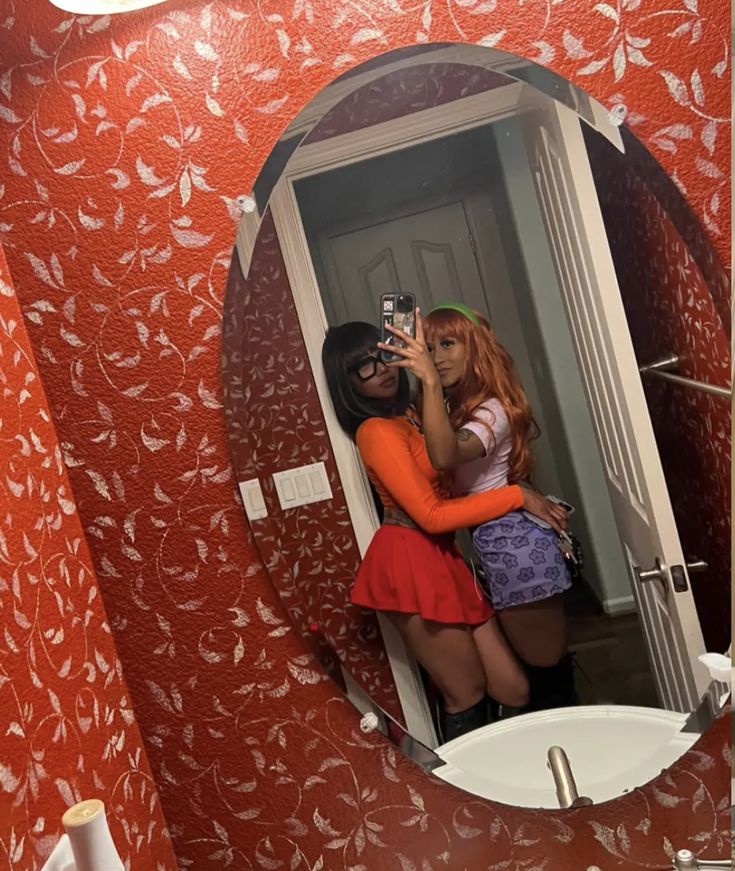 two women are taking a selfie in the bathroom mirror while looking at their reflection