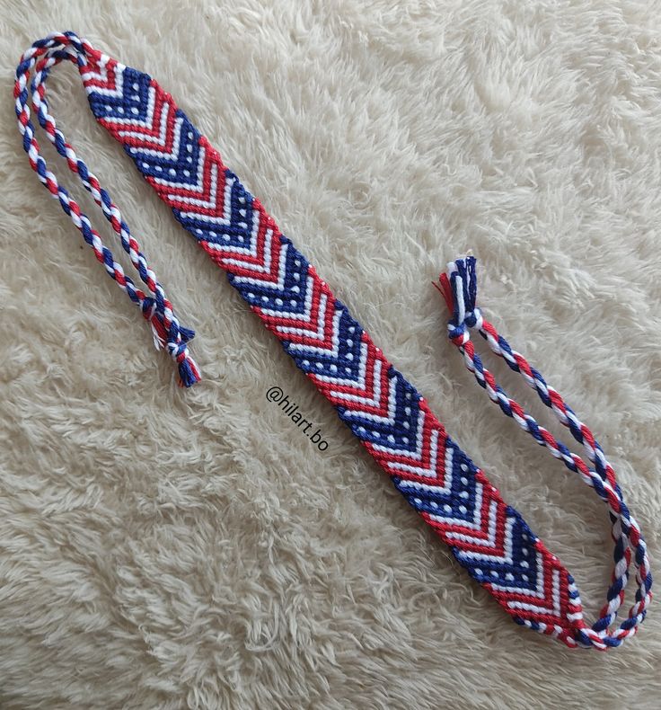 a red, white and blue braided lanyard laying on top of a rug