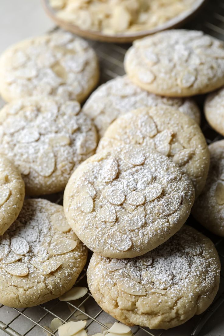 a pile of cookies sitting on top of a cooling rack covered in powdered sugar