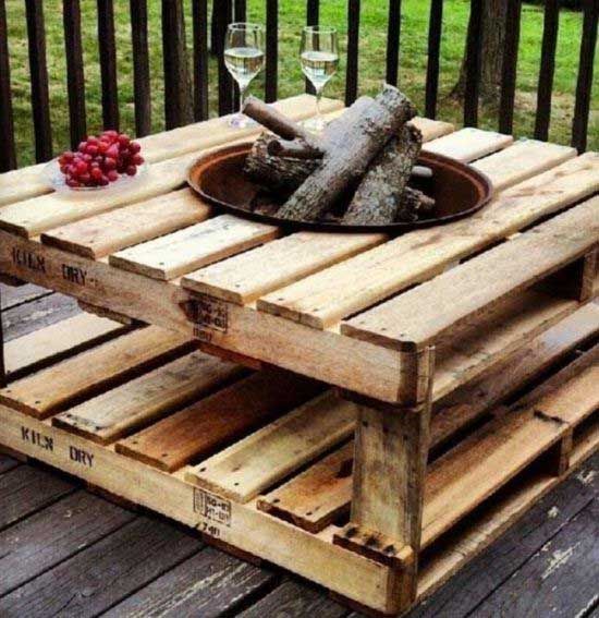 an outdoor table made out of wooden pallets with wine glasses and fruit on top