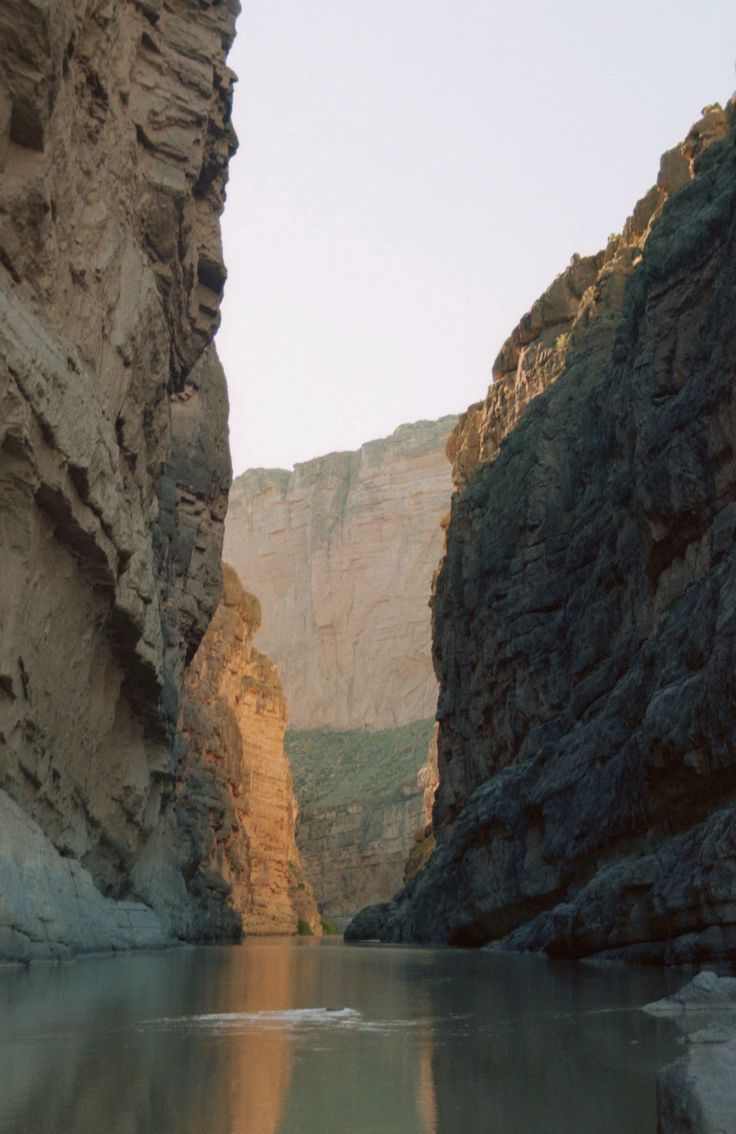 a narrow river surrounded by mountains and cliffs