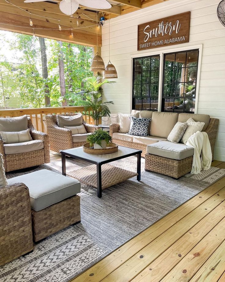 an outdoor living room with wicker furniture and wood flooring on the outside porch