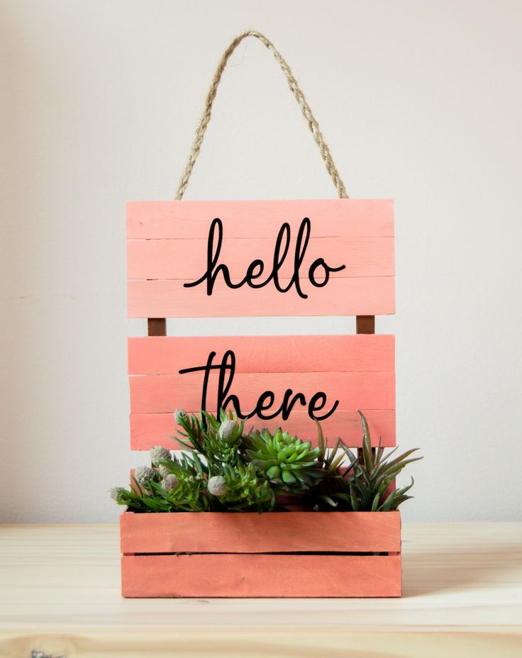 a wooden sign that says hello there with succulents in it