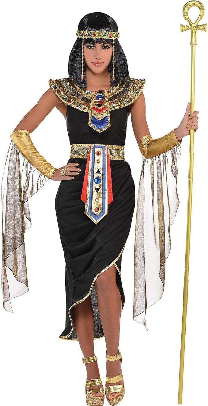 an egyptian woman dressed in black and gold holding a golden staff with her hands on the hips