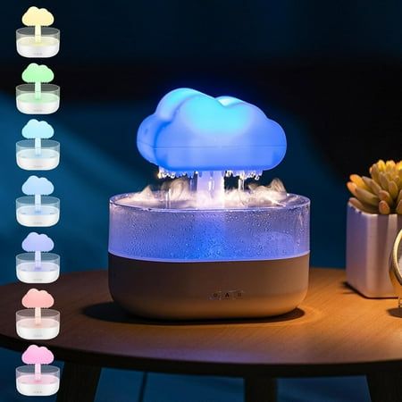 a cloud shaped light on top of a table next to a clock and other items