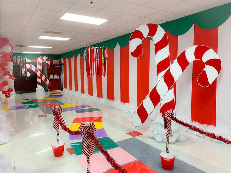 candy canes are on display in the hallway decorated with red and white striped paper