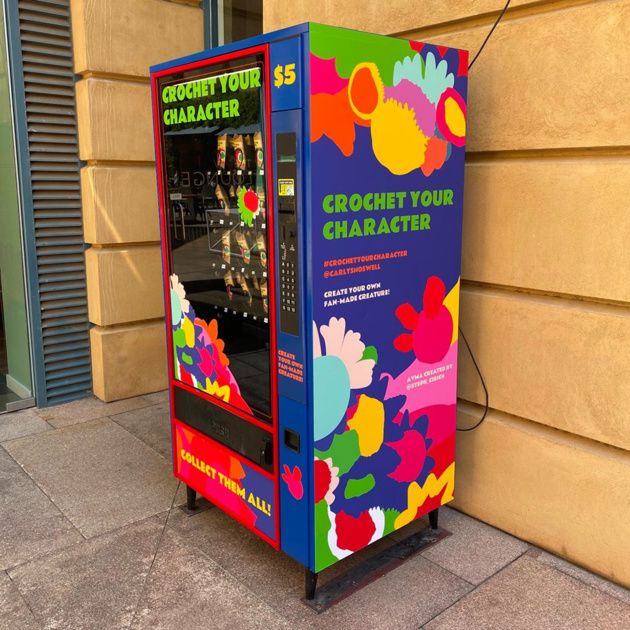 a colorful vending machine sitting next to a building