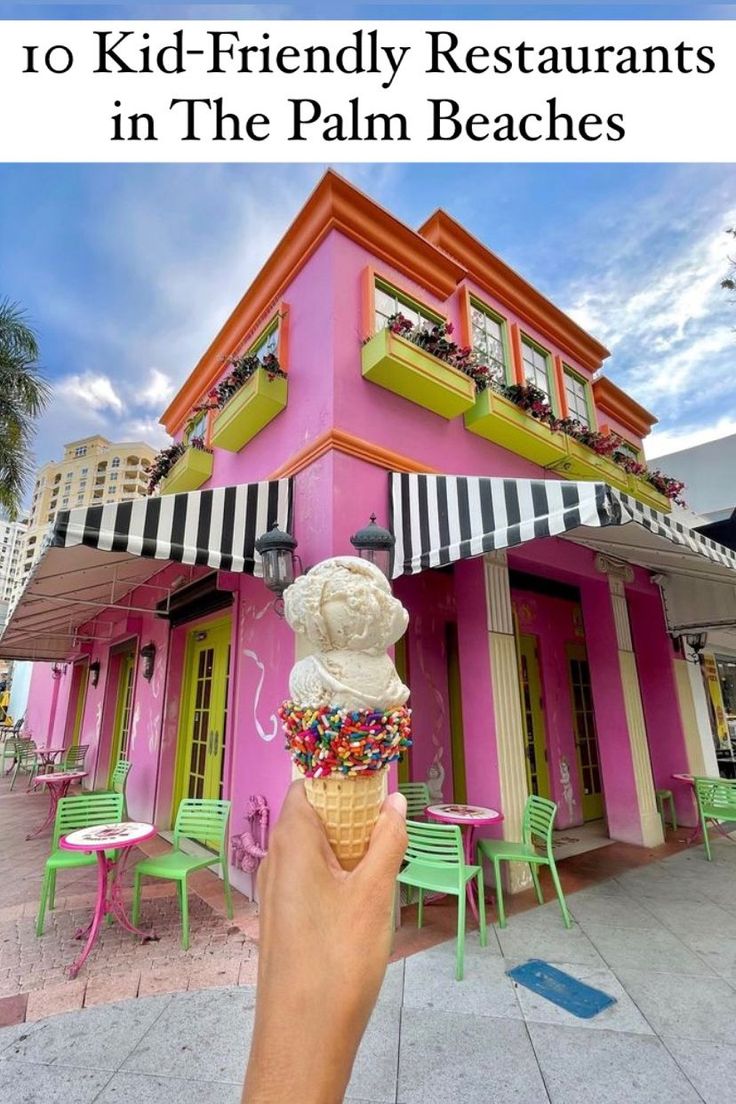 a person holding an ice cream cone in front of a pink building