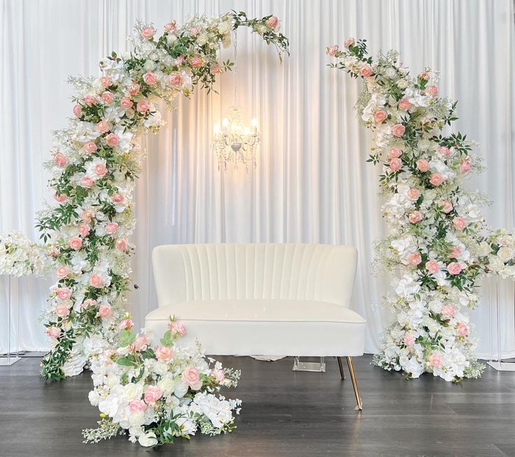 a white couch sitting under a floral arch