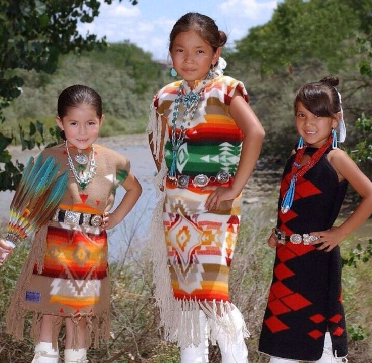 three girls in native clothing standing next to each other