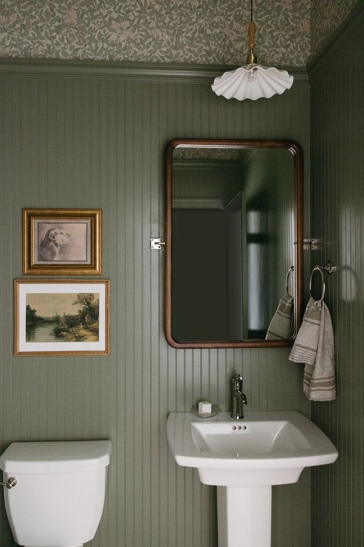 a white sink sitting under a bathroom mirror