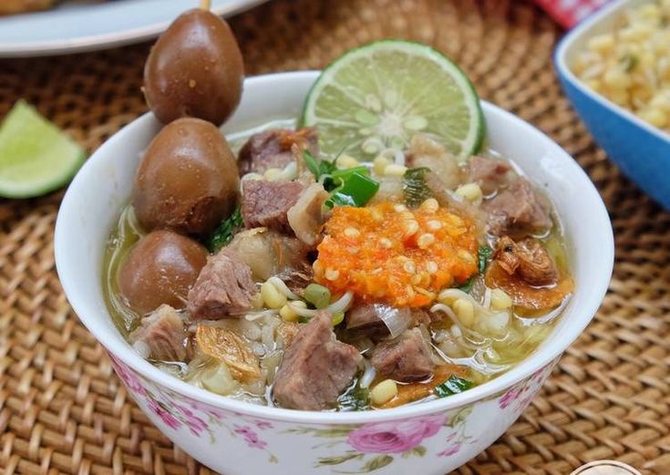 a bowl filled with meat and vegetables on top of a table