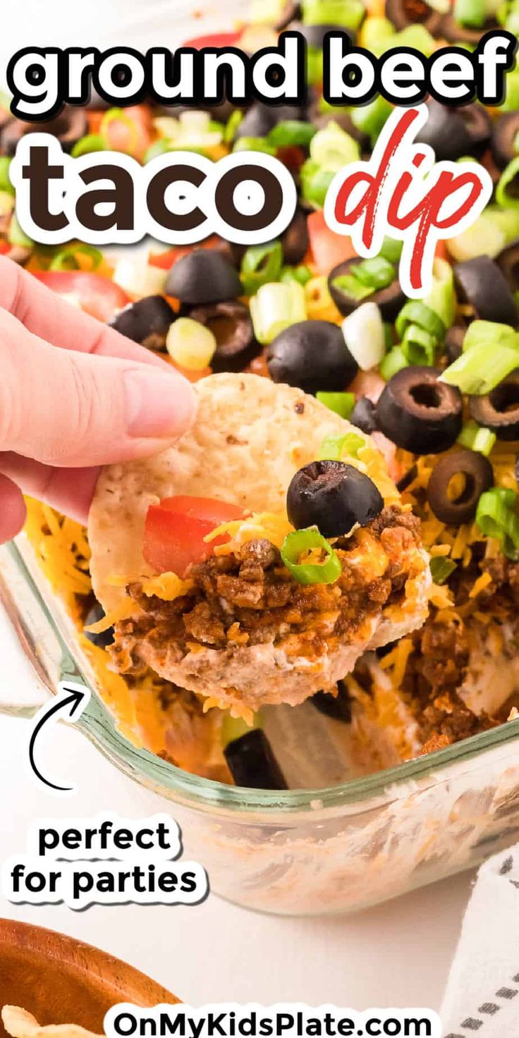 ground beef taco dip in a casserole dish with black olives and cilantro